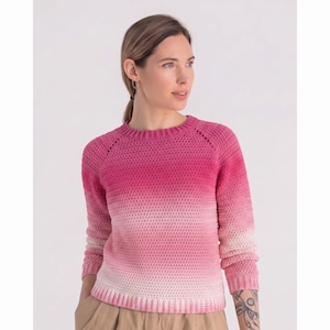 May include: A long-sleeved crochet sweater featuring a gradient color pattern that transitions from a deep magenta at the crew neckline down to a light, pale pink at the ribbed hem and cuffs. The garment has a textured stitch and raglan sleeves.