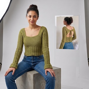 May include: A long-sleeved olive green crochet top featuring a square neckline, a ribbed waist, and flared cuffs. The back of the top includes an open design with a tie closure at the upper back, showcasing the texture of the crocheted yarn.
