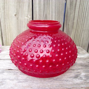 May include: A red glass lampshade with a textured, bubbled surface. The lampshade is round and has a wide opening at the top.