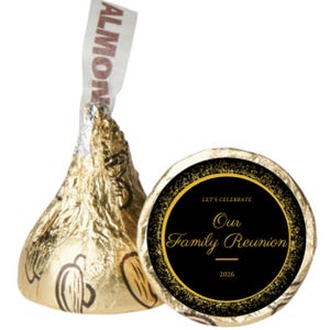 May include: A gold foil-wrapped chocolate candy with an almond filling, next to a black and gold circular label. The label reads "Let's Celebrate Our Family Reunion 2026."