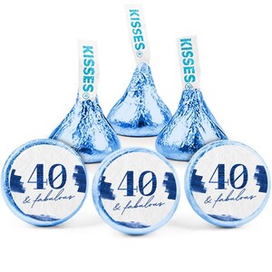 May include: A collection of Hershey's Kisses candies with blue foil wrappers and white paper tags. The candies are paired with round stickers that read "40 & fabulous" in blue and white, perfect for a 40th birthday celebration.