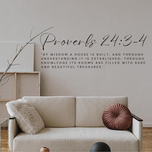 May include: A black wall decal featuring the text Proverbs 24:3-4 and the quote: By wisdom a house is built, and through understanding it is established; through knowledge its rooms are filled with rare and beautiful treasures. The lettering is black.