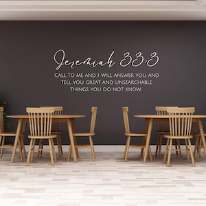 May include: A dining room scene featuring two wooden tables, each surrounded by four matching chairs. The tables and chairs are light brown. The wall is dark gray with the text "Jeremiah 33:3" and a quote in white. Potted plants flank the tables.