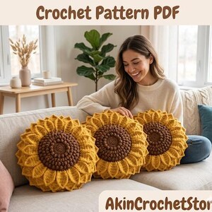 Op de afbeelding: Drie gehaakte zonnebloemkussens met gele bloemblaadjes en bruine centra worden getoond op een beige bank. De kussens zijn rond en hebben een getextureerd uiterlijk. De tekst "Crochet Pattern PDF" staat bovenaan de afbeelding.