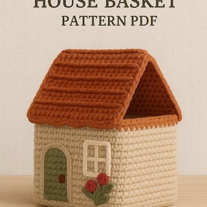 Peut inclure: Panier en forme de maison crocheté, avec un toit terracotta et des murs beiges. La maison a une porte verte, une fenêtre et des accents floraux rouges et verts. Le texte "CROCHET HOUSE BASKET PATTERN PDF" est en haut.