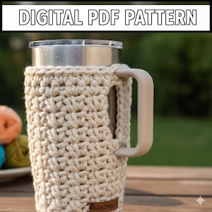 May include: A beige, handmade crochet cozy for a stainless steel tumbler with a handle. The cozy is wrapped around the tumbler and has a handle. The text "DIGITAL PDF PATTERN" is at the top of the image.