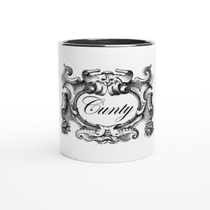 Può includere: Tazza in ceramica bianca con bordo interno nero. La tazza presenta un design ornato in bianco e nero con la parola "Cunty" in una scrittura decorativa. Il design è centrato sull'esterno della tazza.