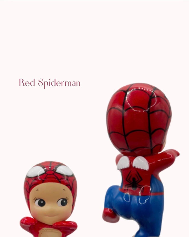 May include: Two red and blue Spiderman figurines. One is a baby-like doll with a red Spiderman mask and outfit. The other is a Spiderman figure with a red head and torso, blue trousers, and white web details.