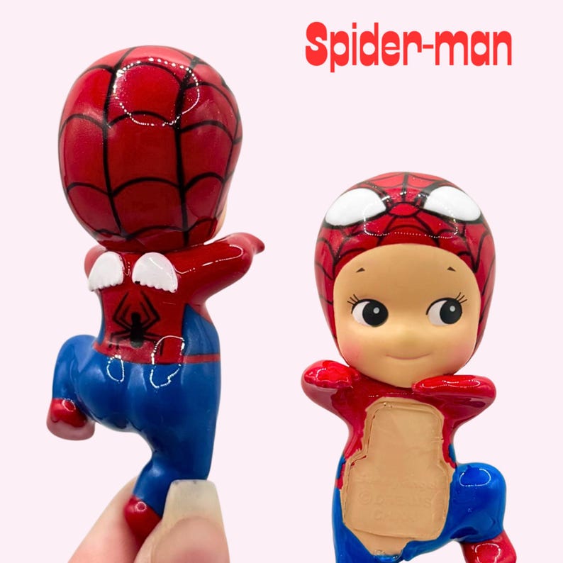 May include: Two views of a Spider-man figurine featuring a red and blue suit with a black spider emblem on the back and small white wings. The character has a round head, large white eyes, and a light skin tone. The text Spider-man is visible.