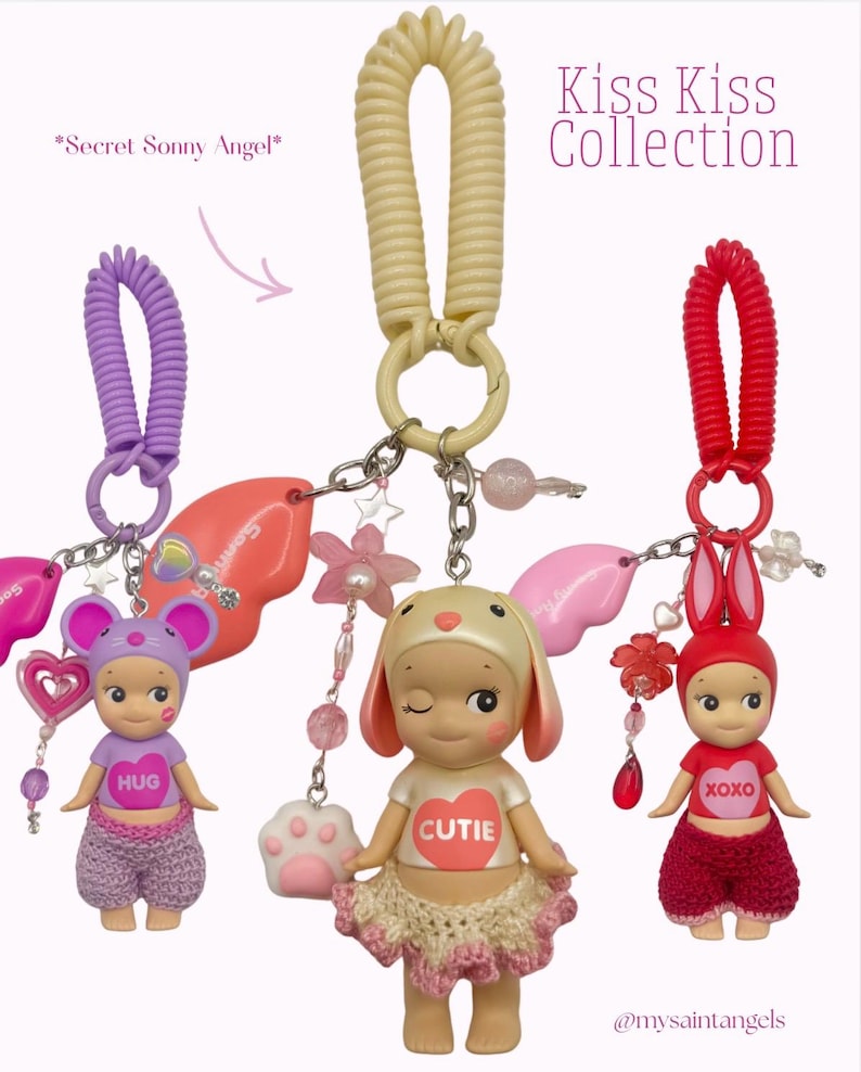 Puede incluir: Tres figuras de Sonny Angel de la colecci&oacute;n Kiss Kiss, cada una con un sombrero y atuendo tem&aacute;tico de animales. Las figuras est&aacute;n unidas a llaveros con dijes y cuentas decorativas. El texto "Kiss Kiss Collection" es visible.
