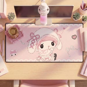 Pu&ograve; includere: Un tappetino da scrivania rettangolare con sfondo rosa chiaro, motivo a rombi bianchi e bordi in pizzo. Al centro &egrave; raffigurato un personaggio dei cartoni animati con lunghe orecchie bianche, fiocchi rosa e un vestito a balze. Include un piccolo coniglio, un cuore e un nastro.