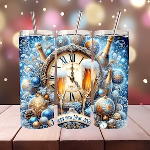 May include: Three stainless steel tumblers with straws, featuring a New Year's Eve design. The design includes a clock, champagne bottles, champagne flutes, and festive ornaments in blue and gold. The text "Happy New Year 2026" is also visible.