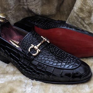 Side view of mens luxury black loafers showing textured leather and sleek silhouette