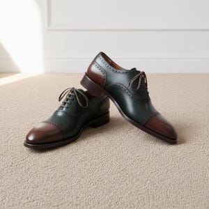 Side angle of mens two-tone oxford dress shoes showing green leather and brown cap toe accents