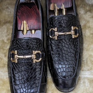 Top view of crocodile pattern loafers highlighting metal horsebit detail