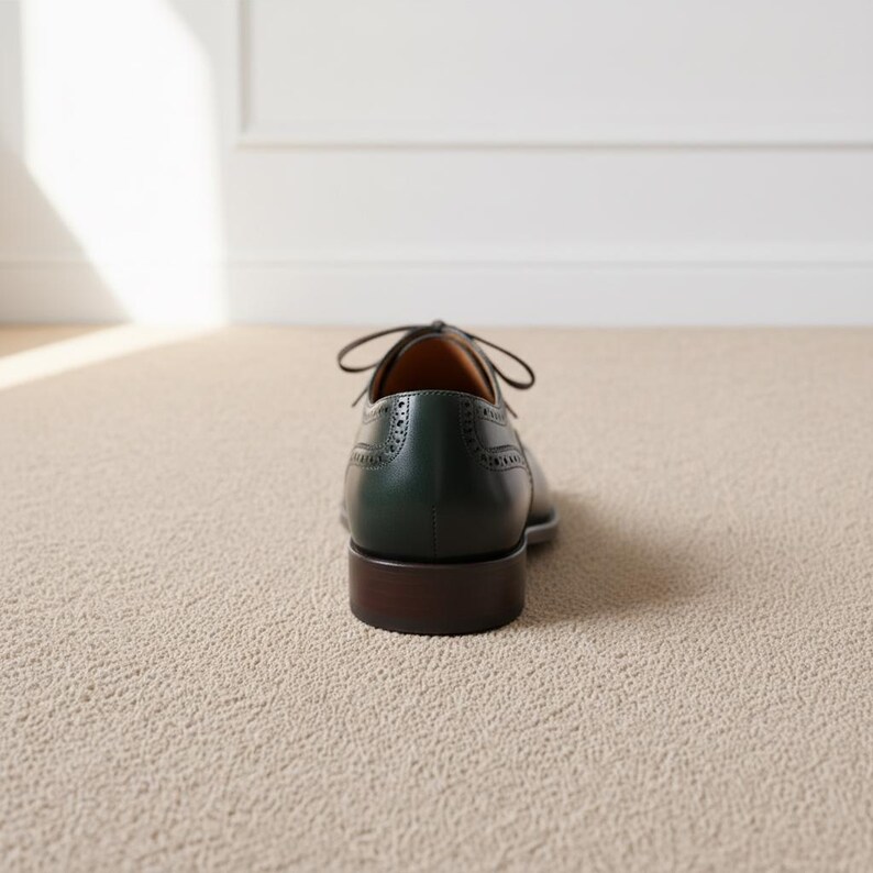 Close-up of perforated cap toe detailing on luxury green and brown leather oxford shoes