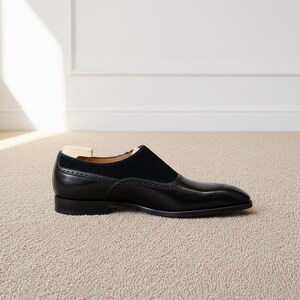 Luxury mens black formal loafers with monk strap styling and minimalist polished silhouette