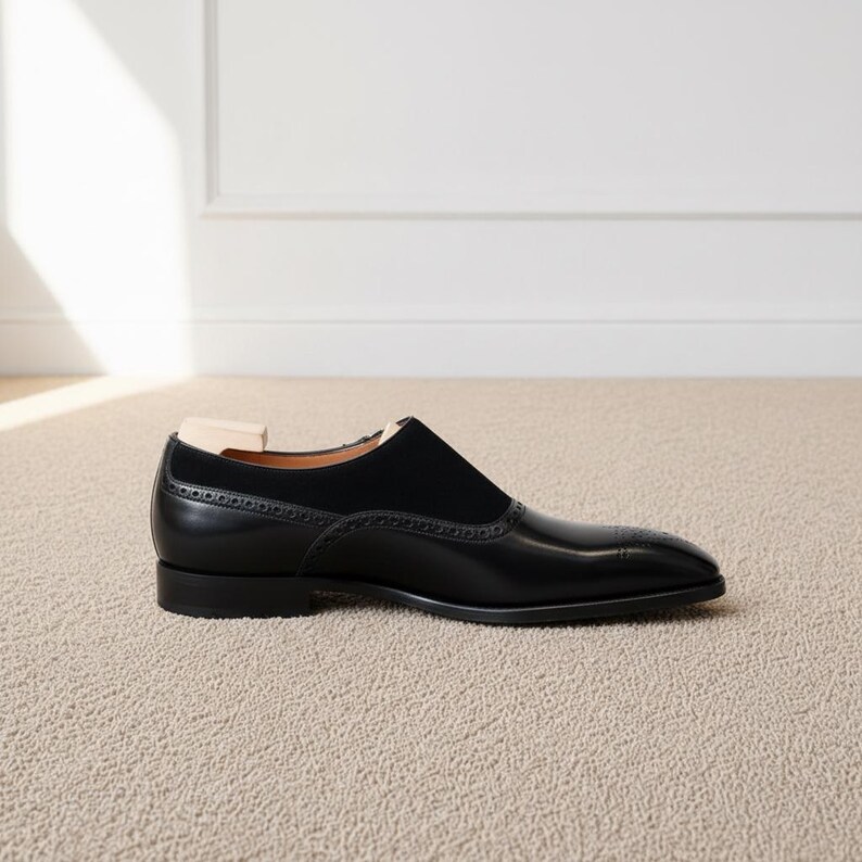 Luxury mens black formal loafers with monk strap styling and minimalist polished silhouette