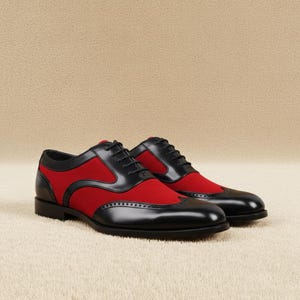 Pair of men's black and red two-tone wingtip brogue oxford dress shoes with lace-up closure, staggered three-quarter front view on a beige background