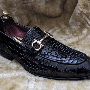Top view of crocodile pattern loafers highlighting metal horsebit detail