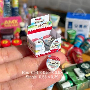 May include: Miniature Kinder Creamy display box with individual servings. The box measures 0.91 x 0.59 x 0.98 inches, and each single serving is 0.55 x 0.39 inches. The packaging features red, white, and blue colors with the text "Kinder Creamy".