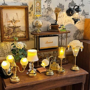 Puede incluir: Decoración en miniatura de estilo antiguo con una variedad de objetos. Incluye un cuadro enmarcado, un reloj, un globo terráqueo, un gramófono, un altavoz Marshall y varias lámparas pequeñas con iluminación cálida. La escena está ambientada sobre una superficie de madera.