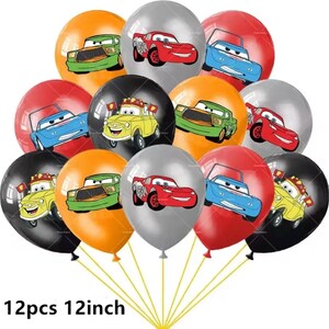 Pode incluir: Um conjunto de 12 bal&otilde;es coloridos, cada um com 30 cm de di&acirc;metro, com desenhos de carros de desenho animado em vermelho, azul, verde, amarelo e prata. Os bal&otilde;es est&atilde;o amarrados, com o texto "12pcs 12inch" na parte inferior.