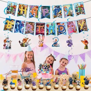 Może przedstawiać: Scena przyjęcia urodzinowego z banerem z napisem "HAPPY BIRTHDAY" i postaciami z popularnego filmu animowanego. St&oacute;ł jest nakryty babeczkami, ciastem i dekoracjami. Trzy młode dziewczyny uśmiechają się do kamery.