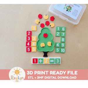 May include: A math learning set featuring a green tree-shaped board, red and yellow apple-shaped tokens, and square tiles with numbers one through ten in red, yellow, and green. A horizontal tray displays the equation 1 + 2 = 3 with tiles.