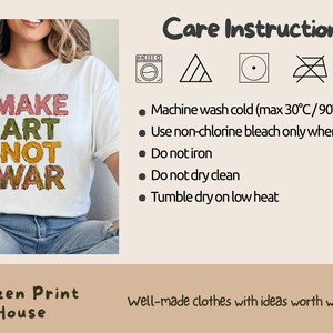 K&ouml;nnte beinhalten: Wei&szlig;es T-Shirt mit dem Text "MAKE ART NOT WAR" in farbenfrohen, strukturierten Buchstaben. Das Shirt enth&auml;lt Pflegehinweise und das Logo von Citizen Print House. Das Shirt ist ein Freizeitartikel.