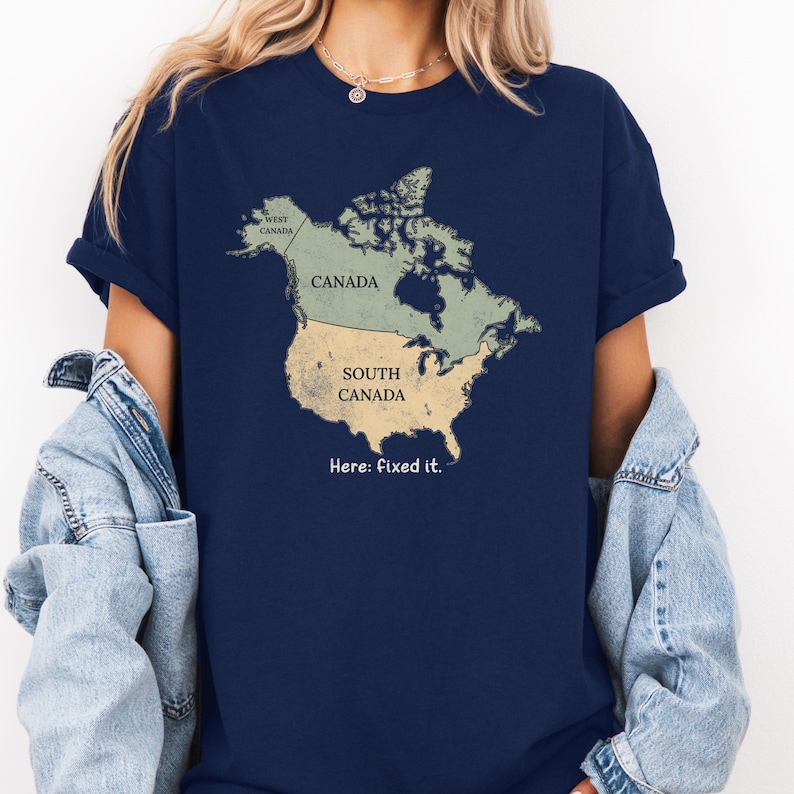 May include: A navy blue short-sleeve t-shirt featuring a graphic of North America. The map is divided into two sections labeled Canada and South Canada, with a small section labeled West Canada. The text below the map reads: Here: fixed it.