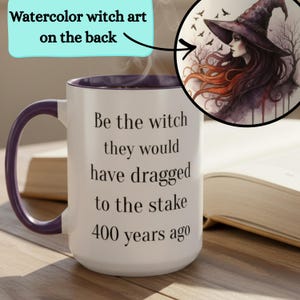 May include: White ceramic mug with a purple interior and handle. The mug features the text "Be the witch they would have dragged to the stake 400 years ago." A watercolor illustration of a witch in a hat is on the back.