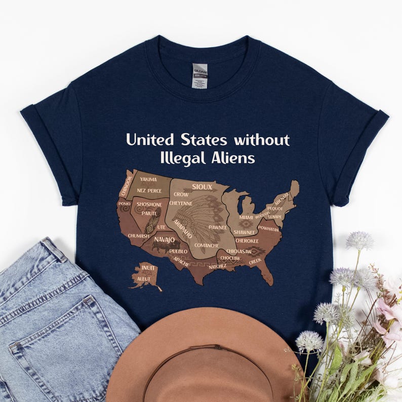 K&ouml;nnte beinhalten: Marineblaues T-Shirt mit dem Text "United States without Illegal Aliens" &uuml;ber einer braunen Karte der Vereinigten Staaten, mit Namen amerikanischer Ureinwohner. Eine blaue Jeans und ein brauner Hut liegen neben dem T-Shirt.