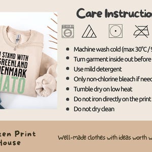 Op de afbeelding: Beige sweatshirt met de tekst "I STAND WITH GREENLAND DENMARK NATO" in zwart en groen. Onderhoudsinstructies rechts. Onderdeel van de Citizen Print House collectie.