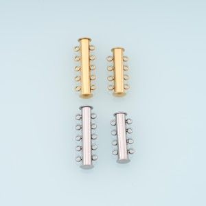 May include: Four multi-strand clasps in gold and silver tones. Each clasp has multiple loops for attaching jewelry strands. The clasps are cylindrical with rounded ends and are arranged in pairs against a light blue background.