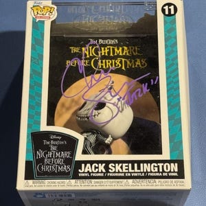 May include: A Funko Pop! vinyl figure of Jack Skellington from Tim Burton's "The Nightmare Before Christmas." The figure is in its original box, which features the movie's logo and a purple signature. The box is marked with the number 11.