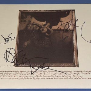 May include: A Pixies album cover with a sepia-toned image of a woman in a frame, signatures, and text. The artwork has a vintage feel, with handwritten signatures and song lyrics at the bottom of the cover.