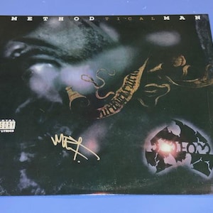 Op de afbeelding: Albumhoes voor "Methodical Man" met een grijswaardenafbeelding van een gezicht. De albumhoes bevat de tekst "Methodical Man", een handtekening en het label Parental Advisory Explicit Lyrics. Het Wu-Tang Clan-logo is ook zichtbaar.