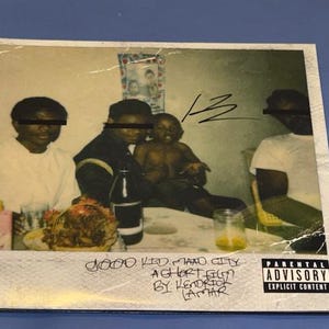 Puede incluir: Una portada de álbum de estilo vintage que muestra a un grupo de personas sentadas alrededor de una mesa con comida y bebidas. La portada del álbum tiene el texto "good kid, m.A.A.d city" y "A short film by Kendrick Lamar".
