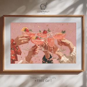 Peut inclure: Une impression encadrée représentant un toast avec des cocktails roses. L'œuvre d'art montre des mains tenant des verres remplis de boissons roses, garnis de fruits. Le fond est rose clair avec des paillettes dorées. Le cadre est de couleur bois clair. Le texte sur le cadre indique "Frame TV Art | 4K Quality + FREE GIFT".