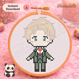 Pode incluir: Bordado em ponto cruz de um personagem de desenho animado em um terno verde, em um bastidor de madeira. O design apresenta um personagem com cabelo loiro, olhos verdes e uma gravata vermelha. As palavras "Download instantâneo" estão no canto superior esquerdo.