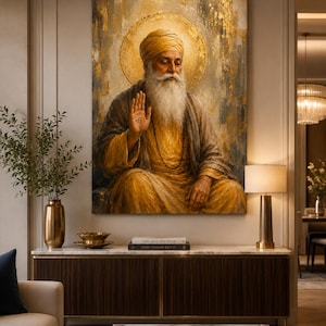 Op de afbeelding: Een verticale wandkunstprint met een bebaarde figuur in een gele tulband en gewaden, met een gouden halo achter het hoofd. De figuur heeft één hand opgeheven in een zegenend gebaar, met een klein symbool op de handpalm, en zit in meditatie.