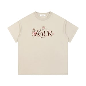 Peut inclure: Un t-shirt beige à manches courtes avec une impression graphique sur la poitrine. Le motif comprend le texte "I AM A KAUR" en lettres marron foncé, agrémenté d'une petite couronne, d'une illustration florale rose et d'un petit cœur.