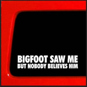 Puede incluir: Una pegatina para la ventana de un coche roja con texto blanco que dice "BIGFOOT SAW ME BUT NOBODY BELIEVES HIM".
