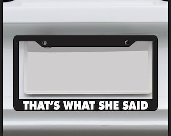 May include: Black license plate frame with the text "THAT'S WHAT SHE SAID" in white letters.