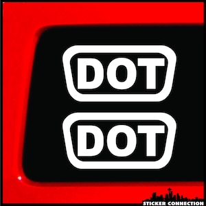 May include: Two white stickers with black outlines and the word "DOT" in black letters. The stickers are on a black background.