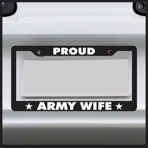 May include: Black license plate frame with white text that reads "PROUD ARMY WIFE" with a star on either side of the text.