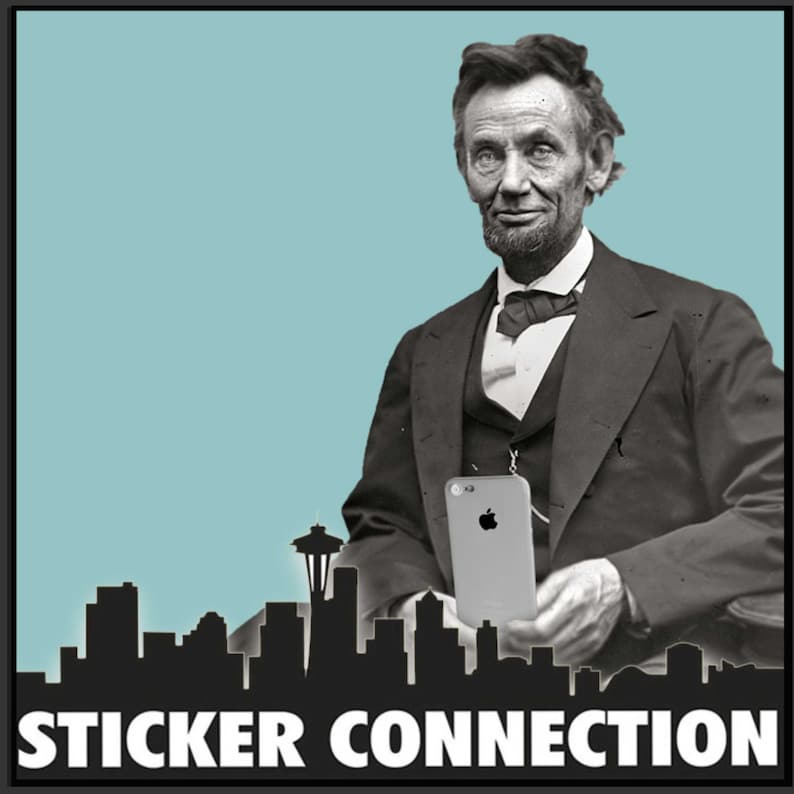 Może przedstawiać: Czarno-białe zdjęcie Abrahama Lincolna trzymającego smartfona przed panoramą Seattle w stanie Waszyngton. Na dole zdjęcia widnieje napis "STICKER CONNECTION".