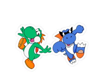 May include: A die-cut sticker featuring two cartoon dinosaur characters. One is green with orange spikes and orange shoes, while the other is blue with orange spikes, orange shoes, and black sunglasses with white lightning bolt accents on the lenses.