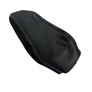 May include: A black motorcycle seat cover featuring a textured, leather-like surface. The cover has a tapered, elongated shape with visible stitched seams along the edges, designed to fit over a standard motorcycle seat frame.
